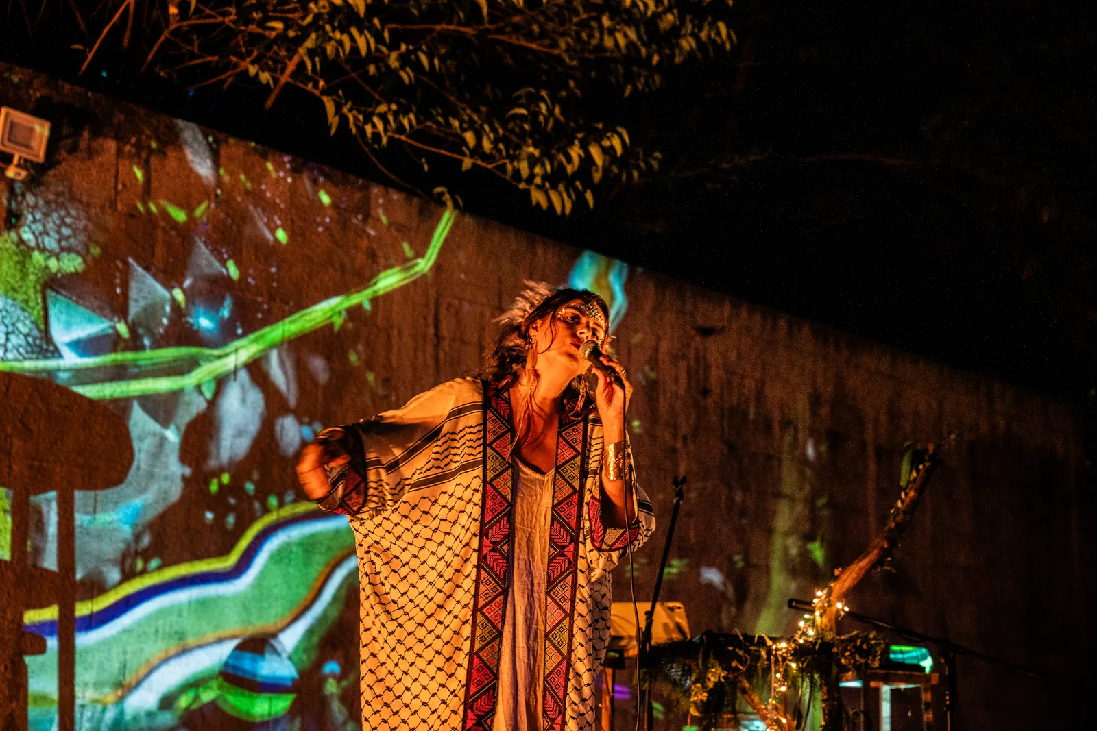 Rawan on stage inside a wash of coloured projection
