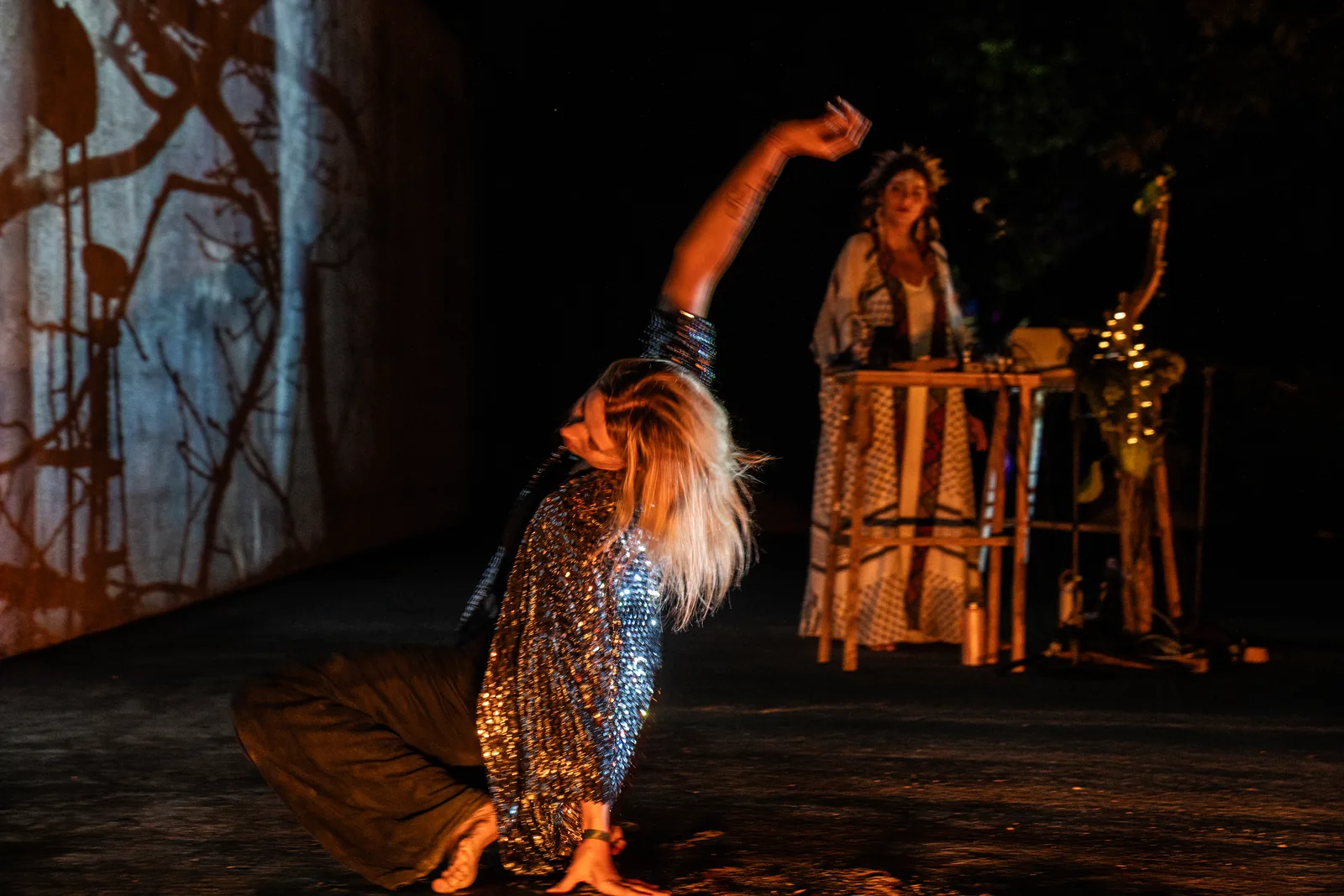 A dancer moves before the projected branches while Rawan sings