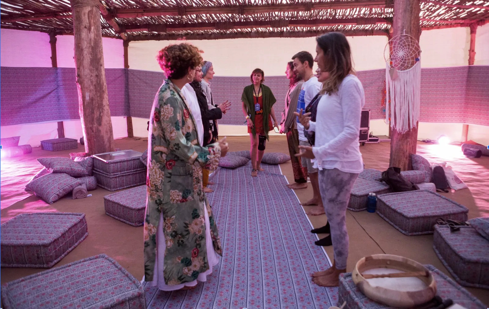 A Conscious Sexuality workshop circle in a pink-lit tent